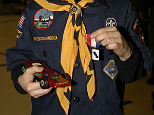 Andrew with his Pinewood Derby car and his third-place ribbon.